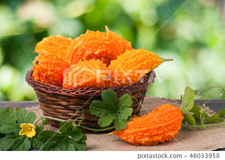 bitter melon or momordica in a wicker basket on wooden table with blurred background 46033958