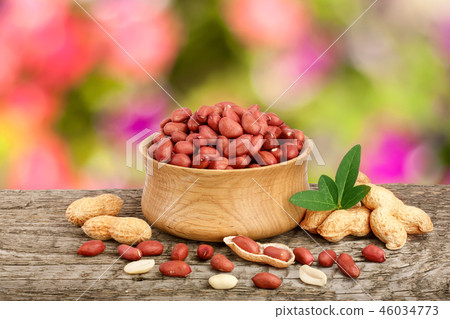 peanuts with leaf in bowl on old on wooden table with a blurry garden background peanuts with leaf in bowl on old on wooden table with a blurry garden background 46034773