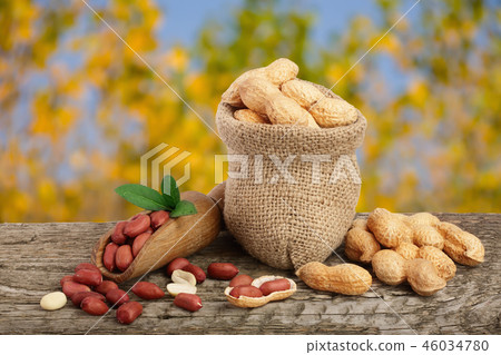 peanuts with leaf in bag on old wooden table with a blurry garden background peanuts with leaf in bag on old wooden table with a blurry garden background 46034780