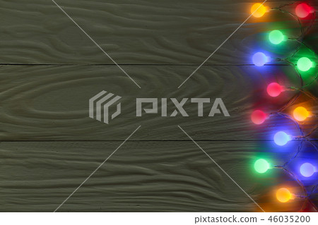 christmas garland lights on dark wooden background with copy space for your text. Top view christmas garland lights on dark wooden background with copy space for your text. Top view 46035200