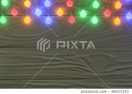 christmas garland lights on dark wooden background with copy space for your text. Top view christmas garland lights on dark wooden background with copy space for your text. Top view 46035203