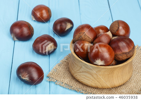 chestnut in wooden bowl on blue wooden background chestnut in wooden bowl on blue wooden background 46035938