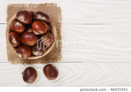 chestnut in bowl on white wooden background with copy space for your text. Top view. Flat lay chestnut in bowl on white wooden background with copy space for your text. Top view. Flat lay 46035941