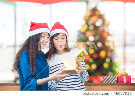 girl friend opening christmas gift box in party girl friend opening christmas gift box in party 46037025