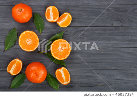 tangerine with leaves on black wooden background with copy space for your text. Flat lay, top view 46037354