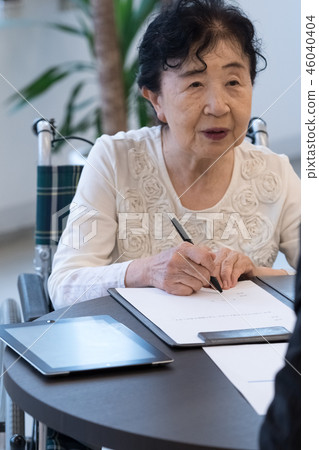 Senior image Senior woman signing paperwork Senior image Senior woman signing paperwork 46040404