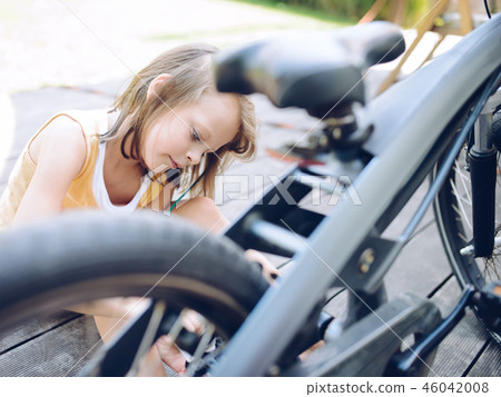 child girl cleaning her bike 46042008