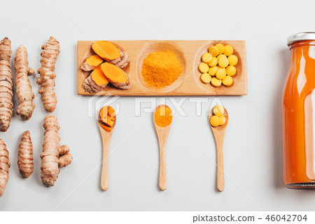 Turmeric in different conditions: fresh, dry root, pills, powder and cut plant. 46042704