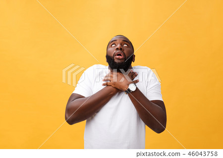 Portrait of african american man with hands raised in shock and disbelief. Isolated over yellow Portrait of african american man with hands raised in shock and disbelief. Isolated over yellow 46043758