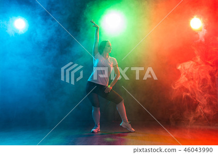 Modern dance, sport and people concept - young woman dancing jazz funk in the darkness under 46043990