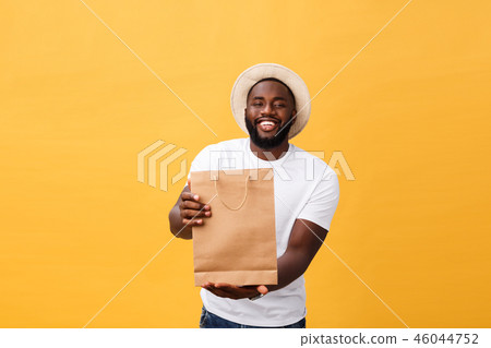 African American man with colorful paper bags isolated on yellow background African American man with colorful paper bags isolated on yellow background 46044752