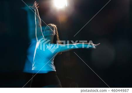 Young slim young woman dancing on a black studio background Young slim young woman dancing on a black studio background 46044987