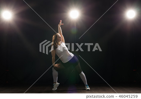 Dance, hip-hop, jazz funk and people concept - flexible young woman dancing in the darkness under 46045259
