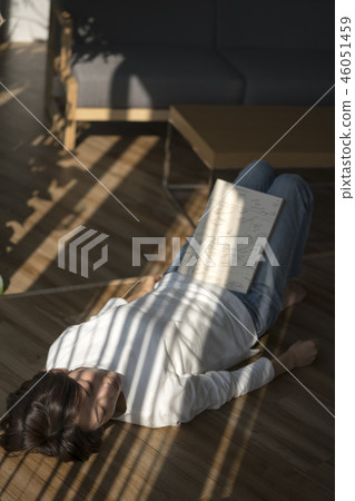 享受與光的婦女讀書在窗簾 享受與光的婦女讀書在窗簾 46051459