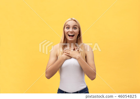 Surprised happy beautiful woman looking at camera in excitement. Isolated on yellow background Surprised happy beautiful woman looking at camera in excitement. Isolated on yellow background 46054825