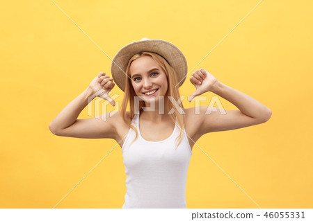 Clothing, design and advertising concept. Indoor shot of positive friendly young female pointing at Clothing, design and advertising concept. Indoor shot of positive friendly young female pointing at 46055331