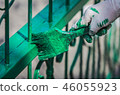 Painting the gate using paintbrush. 46055923