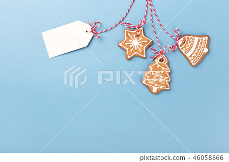 Gingerbread cookies hanging over blue background Gingerbread cookies hanging over blue background 46058866
