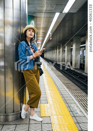 tourist holding cellphone standing on platform tourist holding cellphone standing on platform 46061338