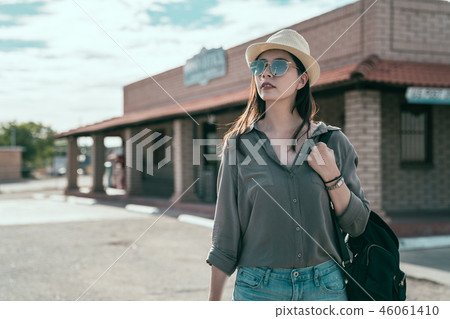 backpacker woman standing on quiet road backpacker woman standing on quiet road 46061410