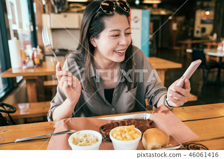 young lady joyfully looking at the cell phone young lady joyfully looking at the cell phone 46061416