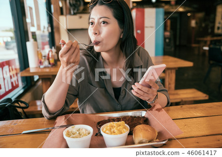 young lady eating meal with fork. 46061417