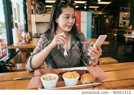 Asian woman using cellphone and upload the photo Asian woman using cellphone and upload the photo 46061418