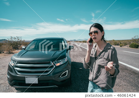 asian girl near a broken car on the country road 46061424