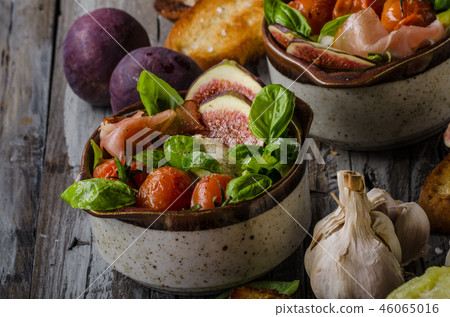 Homemade fresh figs salad with herbs and roasted garlic toast 46065016