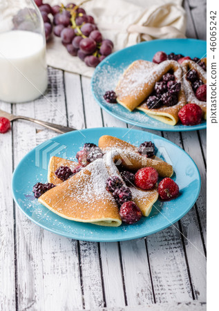 Homemade crepes with frozen berries, topped sugar 46065242