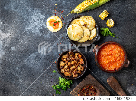 COLOMBIAN traditional food. Chicharron, maize arepas with tomato and onion sauce. Top view COLOMBIAN traditional food. Chicharron, maize arepas with tomato and onion sauce. Top view 46065925