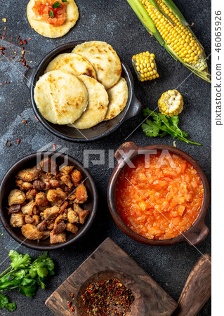 COLOMBIAN traditional food. Chicharron, maize arepas with tomato and onion sauce. Top view COLOMBIAN traditional food. Chicharron, maize arepas with tomato and onion sauce. Top view 46065926