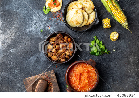 COLOMBIAN traditional food. Chicharron, maize arepas with tomato and onion sauce. Top view COLOMBIAN traditional food. Chicharron, maize arepas with tomato and onion sauce. Top view 46065934