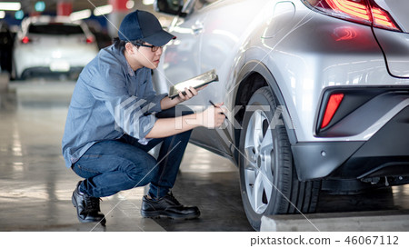 Asian auto mechanic checking the car using tablet Asian auto mechanic checking the car using tablet 46067112