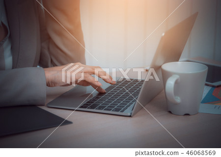 Business woman use laptop and white coffee cup Business woman use laptop and white coffee cup 46068569
