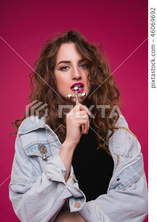 Curly brunette in jeans jacket and gold cross view Curly brunette in jeans jacket and gold cross view 46069692