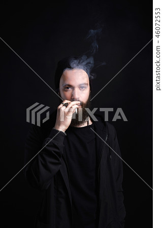 handsome bearded smoking man in Hat 46072553
