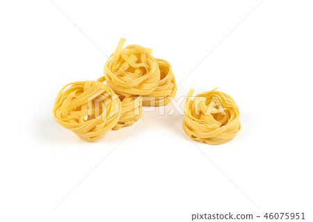 Uncooked nest of tagliatelle pasta isolated on white background. 46075951