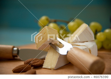 slices of cheese camembert on a cutting board 46076390
