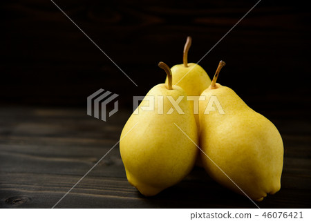 Yellow ripe fresh pears on old wooden board Yellow ripe fresh pears on old wooden board 46076421