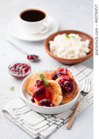 Cottage cheese fritters or syrniki with cranberry sauce 46076957