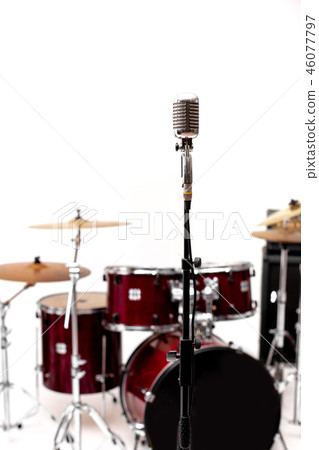 Microphone in a recording studio with drum on background. Microphone in a recording studio with drum on background. 46077797
