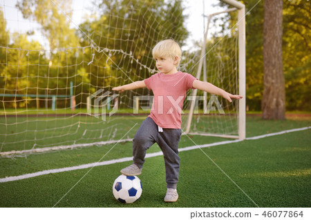 Little boy having fun playing a soccer/football Little boy having fun playing a soccer/football 46077864