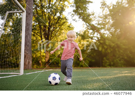 Little boy having fun playing a soccer/football  46077946