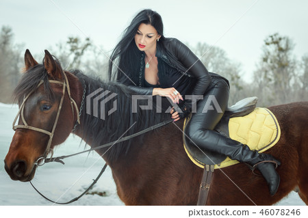 Brunette woman sits on horseback. Brunette woman sits on horseback. 46078246