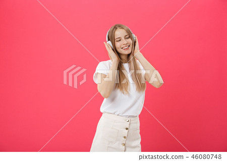 Funny woman with headphones dancing singing and listening to the music from a smart phone isolated Funny woman with headphones dancing singing and listening to the music from a smart phone isolated 46080748