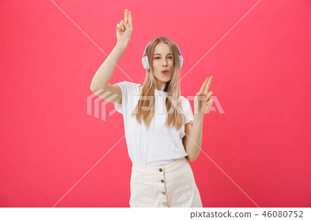 Funny woman with headphones dancing singing and listening to the music from a smart phone isolated 46080752