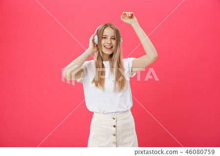 Funny woman with headphones dancing singing and listening to the music from a smart phone isolated 46080759