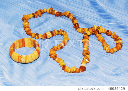 Amber necklace on a light blue background, Amber necklace on a light blue background, 46086429
