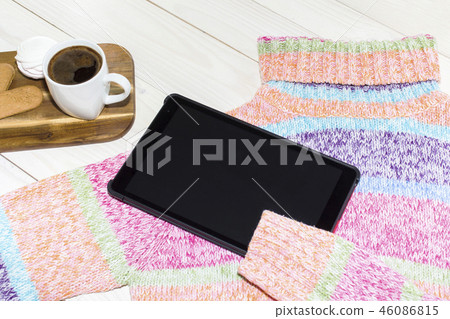 A tablet personal computer with a bright sweater  46086815